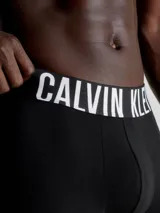 Pack de tres bóxers negros ajustados Calvin Klein de algodón y elastano, con cintura elástica azul con el logo de la marca en blanco.