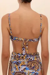 Top de bikini estilo bandeau con estampado abstracto en tonos azul, marrón y amarillo. Presenta breteles delgados, varilla interior y escote con frunces.