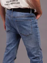 Pantalón jean celeste de corte slim fit y cintura media.