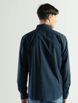 Camisa azul marino de manga larga con cuello abotonado y corte clásico.