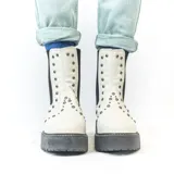 Bota Chelsea color crema con plataforma track negra y elásticos laterales con tachas plateadas.
