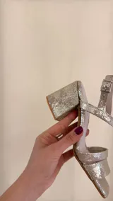 Sandalia dorada de cuero con doble tira delantera, horma cuadrada y ajuste con hebilla.