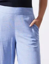 Pantalón crop de lino color celeste, marca Dash, con pretina trasera elastizada y bolsillos inclinados delanteros.