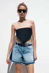 Shorts de jean de tiro medio, corte mom fit, con efecto lavado y terminación desflecada. Presenta cinco bolsillos y cierre frontal con cremallera y botón.