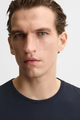 Camiseta slim fit de cuello redondo y manga corta, confeccionada en tejido de algodón con elasticidad.