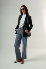 Pantalón de denim azul claro, tiro alto, de corte recto y pierna ancha. Presenta detalles bordados en el área de los bolsillos delanteros y traseros.