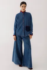Camisa de jean azul con cuello mao, mangas largas y bolsillo de crochet en el pecho.