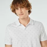 Remera polo blanca de piqué de algodón con estampado de pequeñas figuras negras.