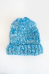 Gorro de lana merino azul con matices celestes y blancos, tejido a mano en punto elástico.