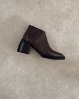 Botín de cuero marrón con estampado de cocodrilo, taco geométrico negro y cierre lateral.