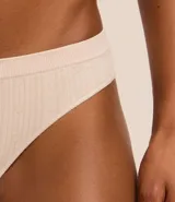 Conjunto de lencería color piel, compuesto por un corpiño tipo top con breteles finos y una bombacha tipo bikini.