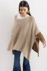 Poncho color beige de algodón tejido, con moldería oversize y tajos en los laterales.