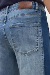 Pantalón de jean wide leg de tiro alto, bicolor, con paneles en gris lavado claro y gris oscuro/negro. Presenta costuras visibles y dobladillo deshilachado en los bajos.