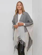 Ruana tejida con diseño colorblock en tonos borgoña, rosa viejo y beige. Presenta flecos en los bordes.