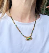 Collar de piedras naturales de malaquita y ojo de tigre con detalles en acero dorado. Dije de acero dorado con detalle de malaquita.