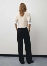 Pantalón de vestir negro de corte recto, con tiro medio, trabillas para cinturón, pinzas frontales y bolsillos laterales.