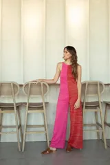 Mono largo de tejido de punto con diseño bicolor en fucsia y rojo, sin mangas, cuello redondo y piernas anchas.