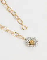 Collar largo dorado con cadena de eslabones gruesos y dije de margarita plateada con centro dorado.