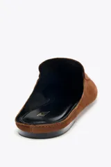 Zapato plano tipo babucha destalonada color marrón, confeccionada en serraje, con detalle de pespuntes en el cerco, copete subido y acabado en punta redonda.