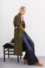 Kimono largo verde oliva con estampado batik en tonos morados. Tiene mangas largas, bolsillos laterales y se ata a la cintura con un cinturón blanco y negro.