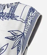 Mono sin mangas confeccionado en viscosa texturizada, con cuello redondo, sisas rayadas, lazo en la cintura y bordados de follaje con paisaje arquitectónico.