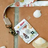 Billetera elástica multicolor con estampado de conchas marinas, con llavero y ranuras para tarjetas.