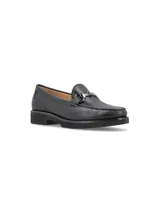 Mocasín de cuero negro con detalle de hebilla metálica plateada.