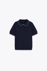 Top azul marino de punto con cuello solapa y manga corta. Detalle de acabados con vivos blancos a contraste en cuello y mangas.