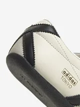 Zapatillas Adidas Tokyo de cuero color crema con detalles en negro, incluyendo las tres tiras laterales y la suela.