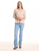 Buzo de tejido suave color beige, con cuello a la base y mangas 3/4 con aplique de botones dorados. Presenta terminación con tajos en los laterales.