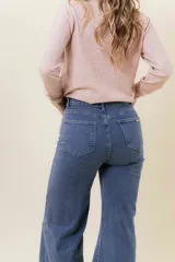 Jean de corte wide leg en color azul medio, con tiro medio, diseño de pierna amplia y fluida, y cinco bolsillos funcionales.