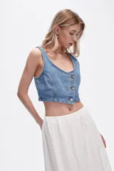 Chaleco crop top de jean celeste con botones frontales.