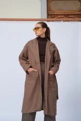 Tapado marrón de lana, corte oversize, con cuello solapa, cierre con botones y cinturón.