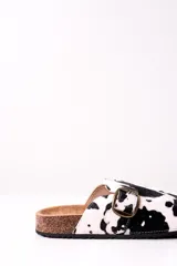 Zuecos con estampado de vaca en blanco y negro, con hebilla metálica ajustable y plantilla de corcho.