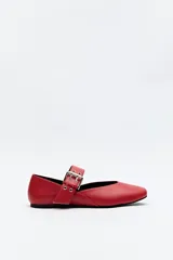 Balerina roja de cuero sintético con punta ligeramente afilada y tira ancha con hebilla metálica.