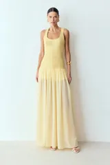 Vestido largo blanco con cuerpo estructurado de algodón y falda fluida de gasa. Tiene tirantes anchos y escote cuadrado.