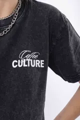 Remera oversize de algodón con efecto acid wash negro/gris, cuello redondo y manga corta. Estampado frontal pequeño con la palabra "Culture" en blanco.