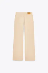 Pantalón de tiro alto color beige, con bolsillos laterales y corte ancho.