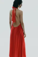 Vestido midi negro de tejido fluido, con cuello halter que se ata al cuello, escote en V y espalda descubierta.