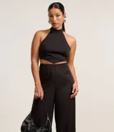 Pantalón de vestir negro de corte recto, sin cintura, con pinzas delanteras y cierre con cremallera y gancho.