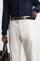 Pantalón chino negro slim fit confeccionado en tejido técnico de secado rápido. Cuenta con bolsillos frontales y traseros de vivo. Cierre frontal con cremallera y botón.