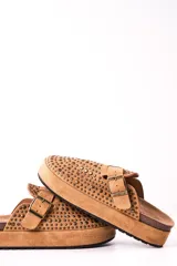 Zuecos color camel con plataforma, detalle de tachas y hebilla dorada.
