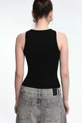 Body negro con hilos dorados, de corte ajustado y sin mangas.