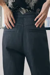 Pantalón de jean azul oscuro, de tiro medio, corte wide leg y bolsillos laterales.