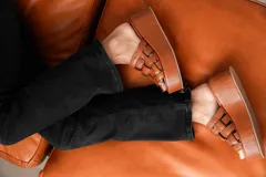 Sandalias negras de cuero con plataforma pareja y tiras de cuero tejidas en la parte superior.