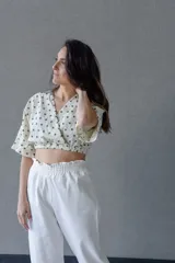 Top cruzado escotado de tusor de algodón con estampado de lunares verdes, cintura elastizada y manga corta holgada.