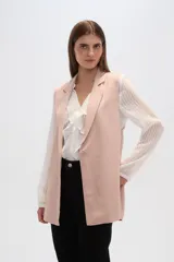 Chaleco color rosa palo, sin mangas, con solapas y cierre frontal con un botón. Confeccionado en lino y viscosa.