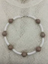 Collar corto con cuentas redondas color lila y cuentas cilíndricas color verde oliva, separadas por anillos dorados.