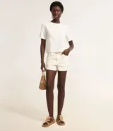 Short de cintura alta color crema, confeccionado en sarga con bordado floral, trabillas en la cintura, cierre tradicional y bolsillos.