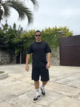 Conjunto negro tejido calado, compuesto por una remera de corte cuadrado y shorts.